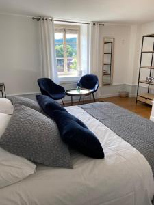 a bedroom with a bed with pillows and a table and chairs at La SAURA in Lusigny-sur-Ouche