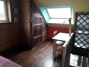 een kamer met een bed, een raam en een houten vloer bij maison d'artiste accès jardin in Maubeuge
