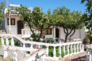 a white fence in front of a house with trees at Villa Italiana in Agios Nikolaos