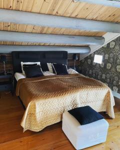 a large bed in a room with a wooden ceiling at Hova Prästgård Bed & Breakfast in Hova