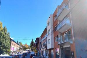 a city street with cars parked on the side of a building at Belgrano Center SCB in San Carlos de Bariloche