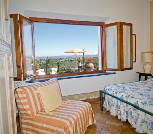 ein Schlafzimmer mit einem Bett, einem Stuhl und einem Fenster in der Unterkunft B&B I Coppi in San Gimignano