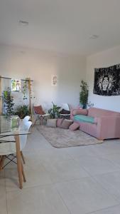 Complejo Junin Dpto Planta Alta في فورموزا: غرفة معيشة مع أريكة وردية وطاولة
