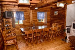a dining room with a table and chairs in a log cabin at Guesthouse Peto in Novi Kneževac