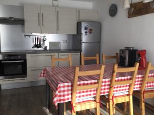 Il comprend une cuisine équipée d'une table, de chaises et d'un réfrigérateur. dans l'établissement Résidence Croix Margot, à Villard-de-Lans
