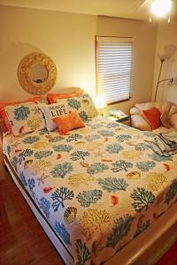 a bedroom with a bed with a comforter on it at Lake Front Modern Beach House-Hatteras Island in Avon
