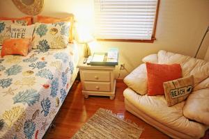 a bedroom with a bed and a couch and a table at Lake Front Modern Beach House-Hatteras Island in Avon