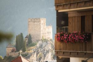 un château au sommet d'une montagne avec des fleurs roses dans l'établissement Alpine Resort Goies Superior, à Ladis