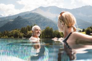 un hombre y una mujer en una piscina en Alpine Resort Goies Superior, en Ladis