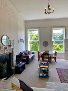 Grosvenor Apartments in Bath - Great for Families, Groups, Couples, 80 sq m, Parking في باث: غرفة معيشة مع أريكة ومدفأة