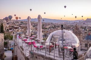 a group of tables and chairs with hot air balloons at Charming Cave Hotel in Goreme