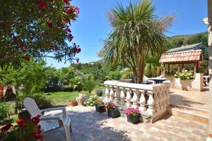Barbaggio的住宿－maison 5 personnes au calme avec jardin et piscine，一个带长凳和鲜花的庭院和一个凉亭