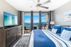 a bedroom with a blue bed and a flat screen tv at Spacious Seaside Beach and Racquet 3706 with Pool and Comfort Amenities in Orange Beach