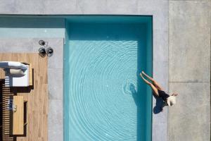 a woman is swimming in a swimming pool at Physis Villas - Metal & Wood in Pigi