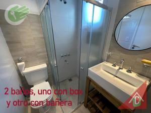 y baño con aseo, lavabo y espejo. en Centro - 2 dorm - 2 baños completos en Mar del Plata