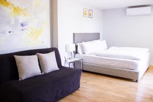 ein Schlafzimmer mit einem Bett und einem Sofa in der Unterkunft Stacey’s Stylish studio in Eilat