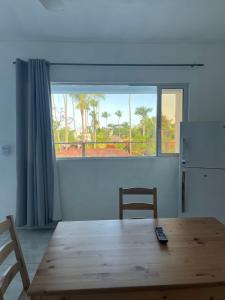 a dining room with a wooden table and a window at Apartamentos Palo Coco in Las Terrenas