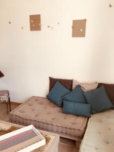 - un salon avec un canapé et des oreillers bleus dans l'établissement Le Clos des Gites, maisons de vacances,, à Châteauneuf-Val-Saint-Donat