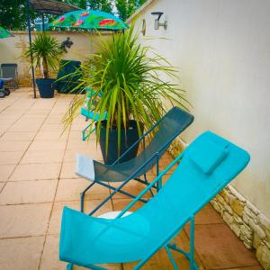 un par de sillas azules y una planta en un patio en Le Clos des Gites, maisons de vacances,, en Châteauneuf-Val-Saint-Donat