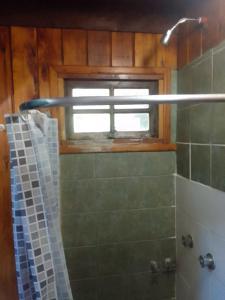 y baño con ducha y ventana. en San Ignacio en San Carlos de Bariloche