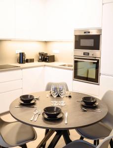 eine Küche mit einem Tisch mit Tellern und Weingläsern in der Unterkunft Tran Chien Apartment with free private parking in Prag