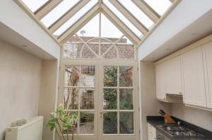 a kitchen with a conservatory with a glass roof at Maison Rose in Ypres