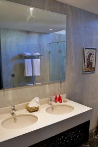 a bathroom with two sinks and a large mirror at Dar Chrifa in Rabat