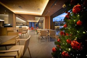 un árbol de Navidad en un restaurante con mesas y sillas en Hotel St. Michael, en Livigno