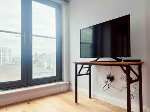a television on a table in a room with a window at 2 bedrooms flat @ London Sutton Station Zone 5 in Sutton