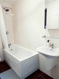 a bathroom with a white tub and a sink at 2 bedrooms flat @ London Sutton Station Zone 5 in Sutton
