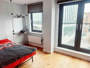 a bedroom with a bed and large windows at 2 bedrooms flat @ London Sutton Station Zone 5 in Sutton