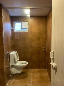 a bathroom with a toilet and a shower with a window at AVVAIRAM SERVICE APARTMENT G8 in Chennai