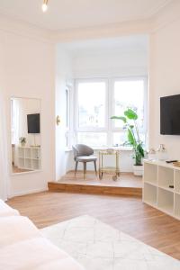 - un salon blanc avec une chaise et une télévision dans l'établissement Honeybee Properties Ferienwohnungen Koblenz, à Coblence