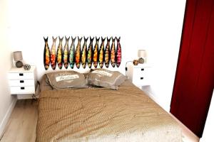a bedroom with a bed with hockey equipment on the wall at La Cotinière, studio avec cuisine 50 m de la plage in La Cotinière