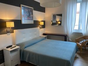 a bedroom with a large bed with a blue blanket at Maison Del Magra in Ameglia