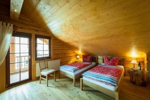 1 Schlafzimmer mit 2 Betten in einem Blockhaus in der Unterkunft Chalet zum Salamander in Ilsenburg