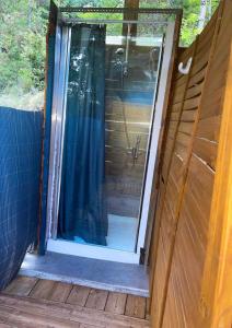 een douche met een glazen deur op een terras bij Caravanes de Provence in Aiglun
