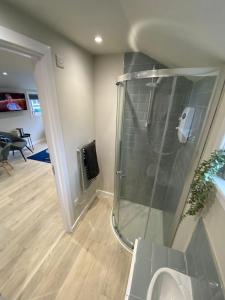 een badkamer met een douche en een glazen wand bij Little Rosslyn in Perth