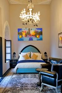 - une chambre avec un grand lit et un lustre dans l'établissement Dar Chrifa, à Rabat