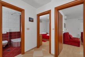 a bathroom with a tub and a red couch in a room at Villa Juric 2 in Baška Voda +42 photos