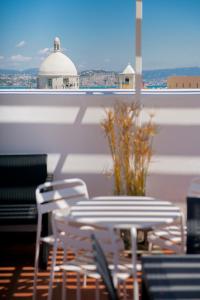 une table et des chaises assises au-dessus du toit dans l'établissement Gioia 13 Rooms & Apartments, à Procida