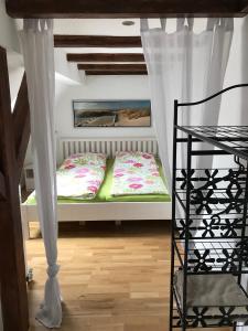 Habitación pequeña con cama con cortinas y escalera en Ferienwohnung Romantica 1. und 2. OG en Schopfloch