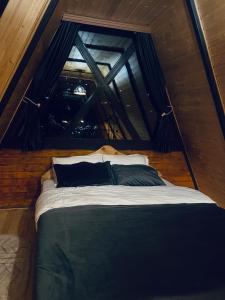 una cama en el medio de una habitación en Darchi • დარჩი en Batumi