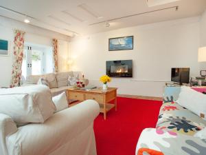 uma sala de estar com dois sofás e uma televisão em The Tithe Barn em Stoke Canon