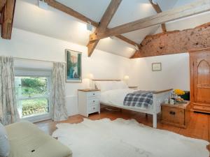 a bedroom with a bed and a window at The Tithe Barn in Stoke Canon