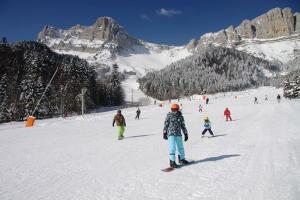 un groupe de personnes skier sur une piste enneigée dans l'établissement Duplex gresse-en-vercors, à Gresse-en-Vercors