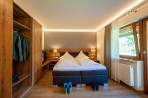 ein Schlafzimmer mit einem Bett und einem Paar blauer Schuhe in der Unterkunft Hotel Landgasthof Oberschnorrhof in Dammbach