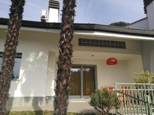 Casa blanca con lámpara roja y palmeras en Villa in Precollina, en Turín