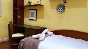 Un dormitorio con una cama y un escritorio con toallas. en Amplio y acogedor cerca del Guggenheim, en Bilbao