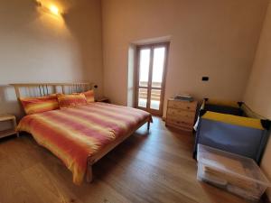 a bedroom with a bed and a dresser and a window at Walking's House Mountain Lake Iseo Hospitality in Lovere